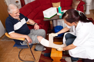 caregiver giving first aid treatment to senior man